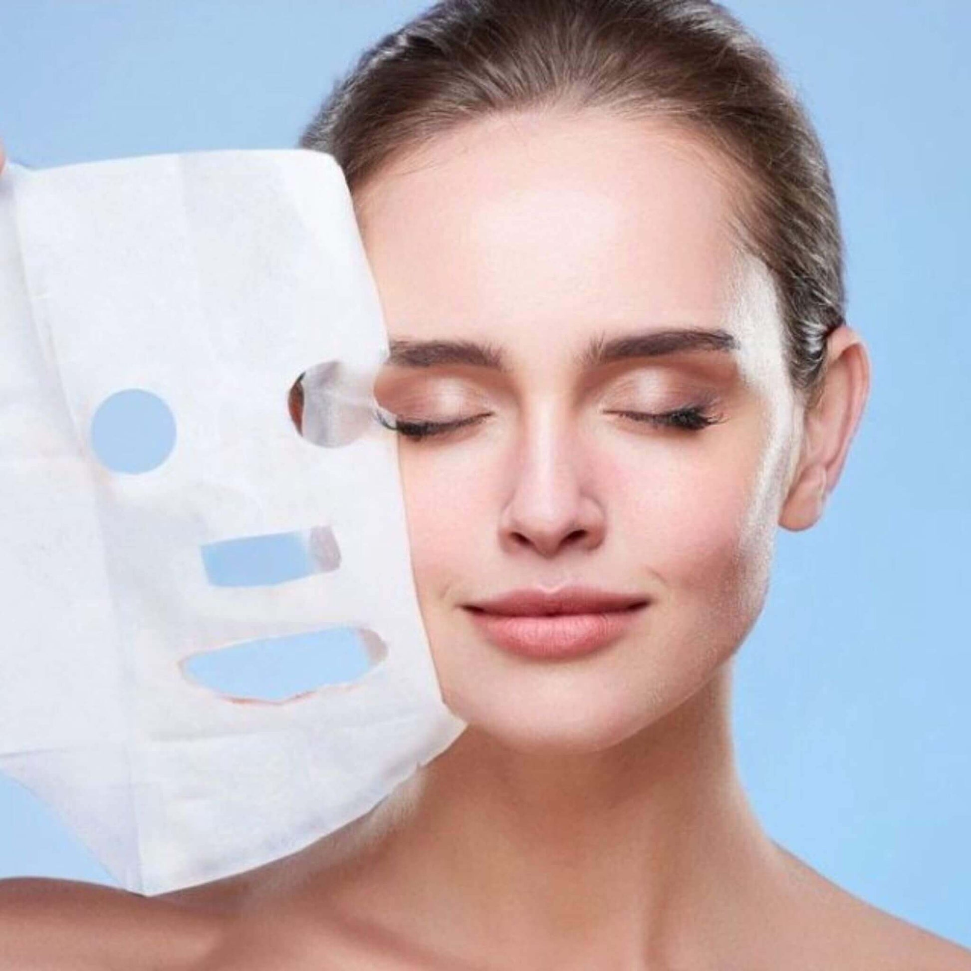 woman is taking off a exfoliating sheet mask