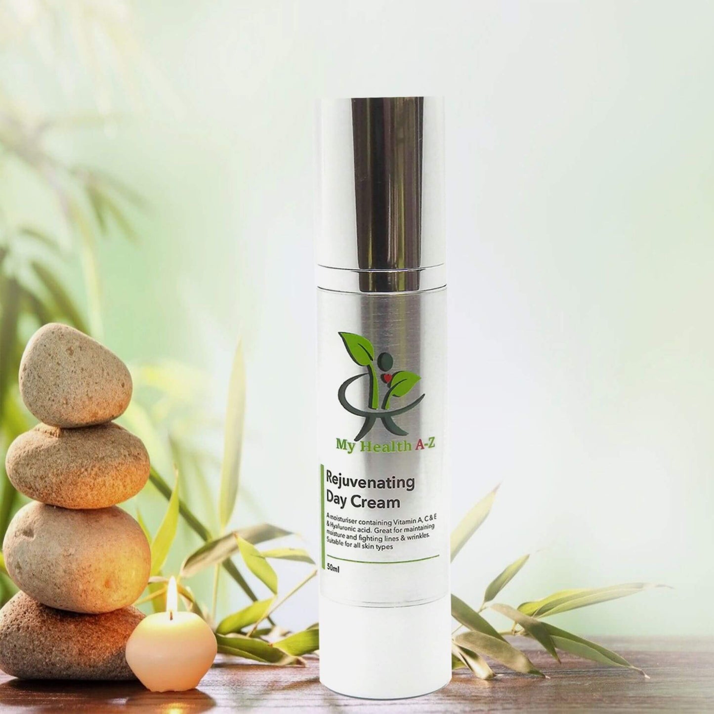 soft green leafs in the background yellow stacked rocks and a bottle of rejuvenating day cream
