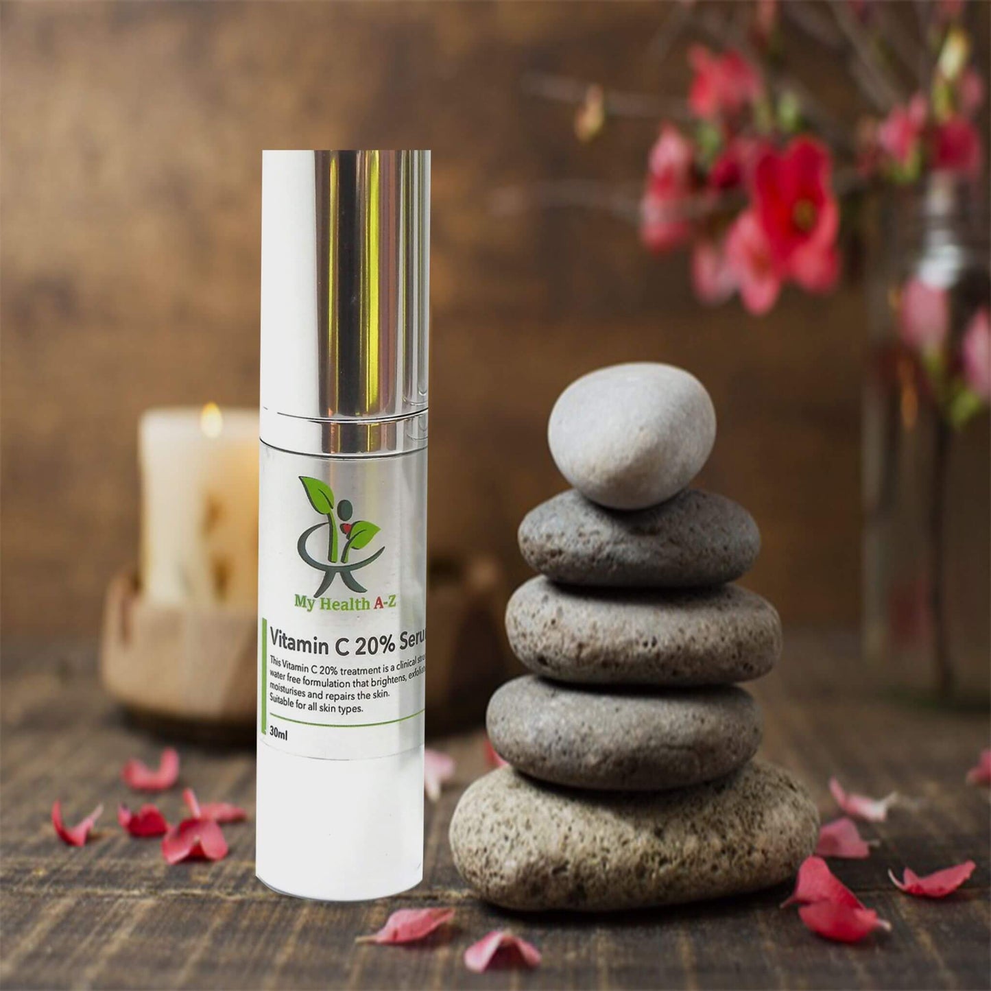 Vitamin C 20% bump bottle with staked stones and candle im background on the right a vase with red flowers