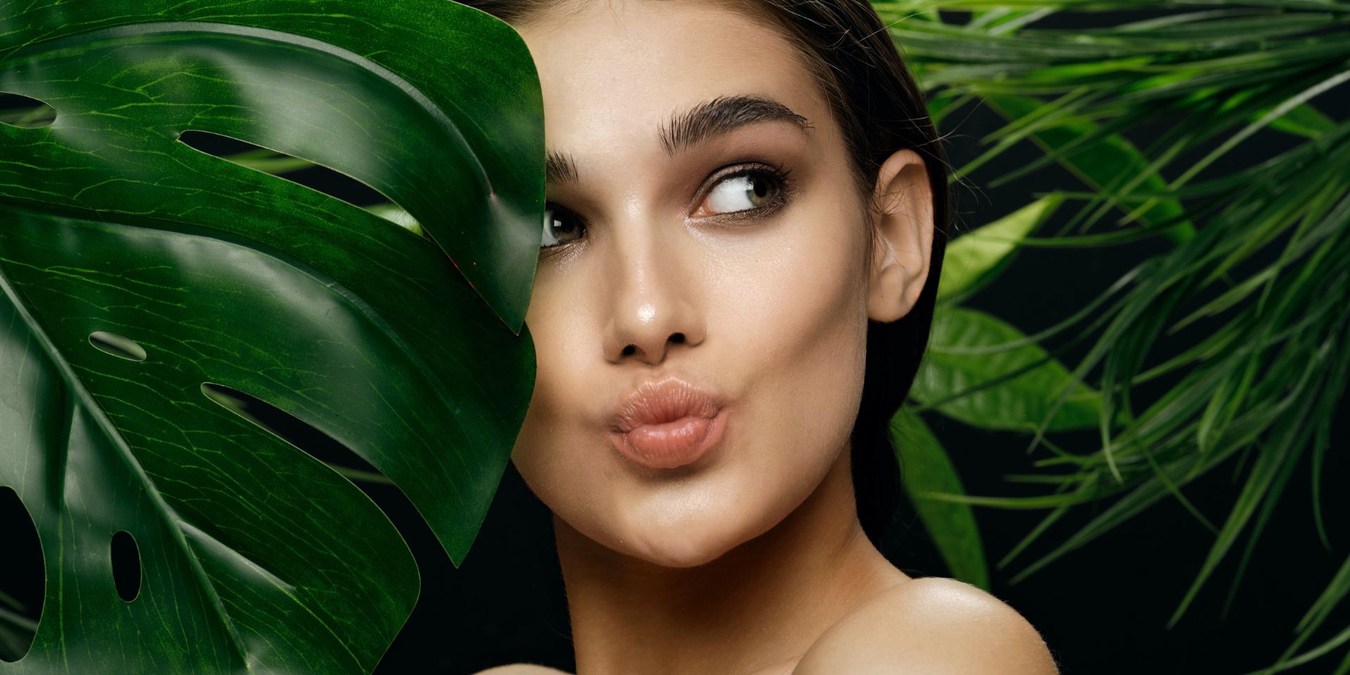 Woman face between green leafs