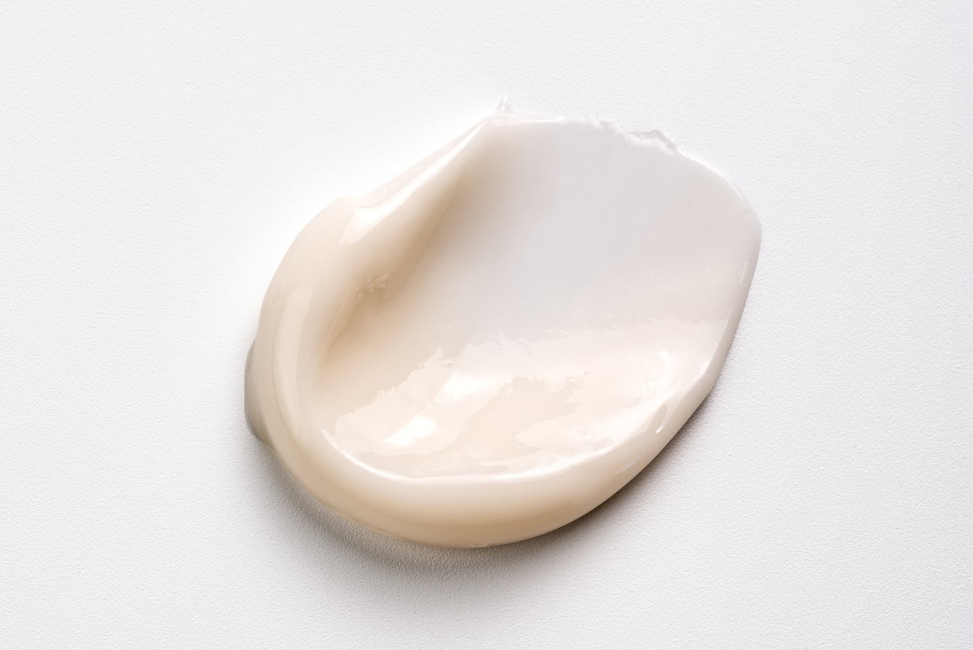 White cream in a teardrop shape on a light grey background
