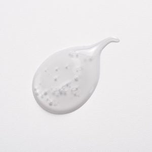 White cream droplet on a light grey background