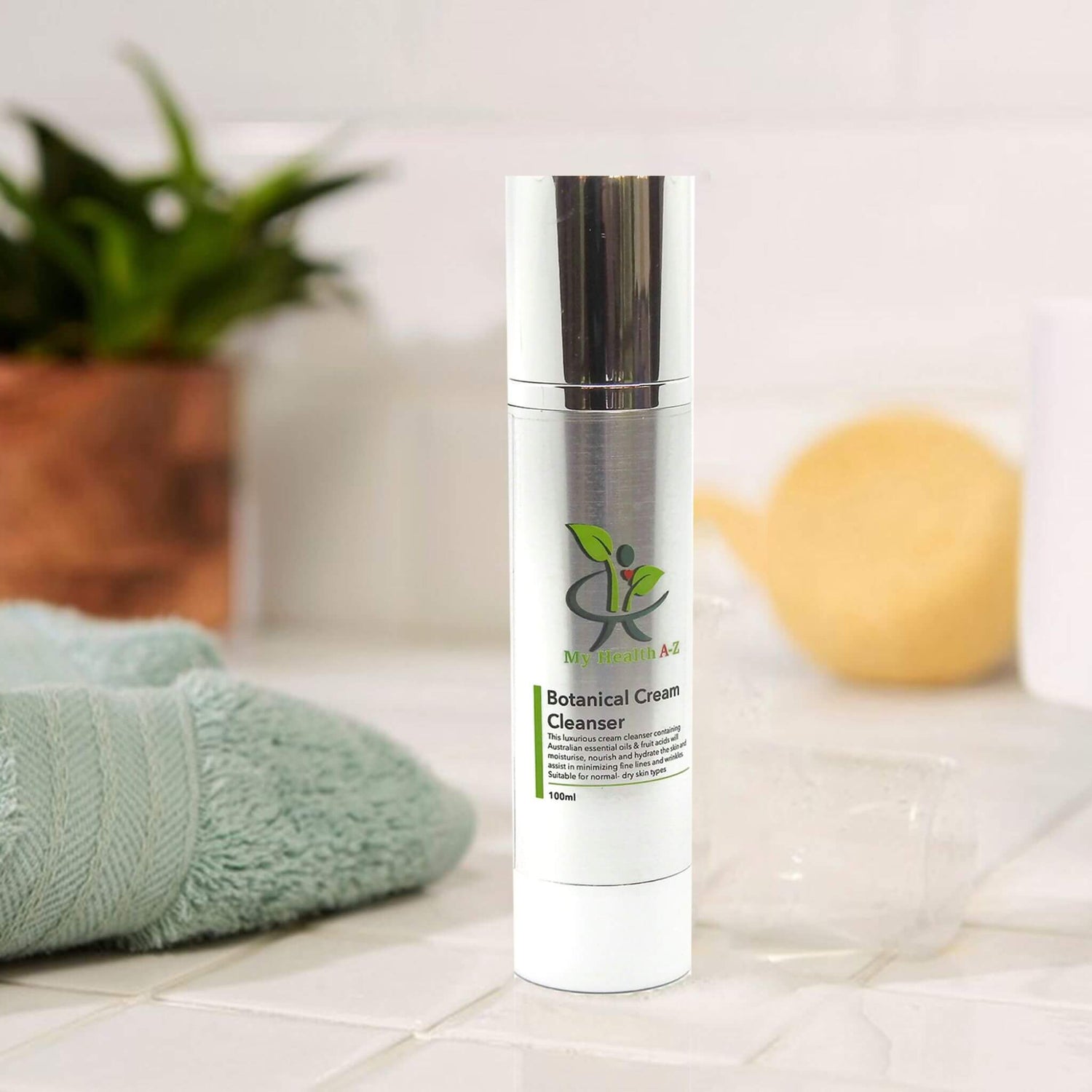 My Health A-Z Botanical Cream Cleanser skincare bottle on a bathroom counter with towel and sponge