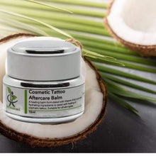 Load image into Gallery viewer, cosmetic tatoo aftercare balm jar on a coconut with coconut leaf in the middle
