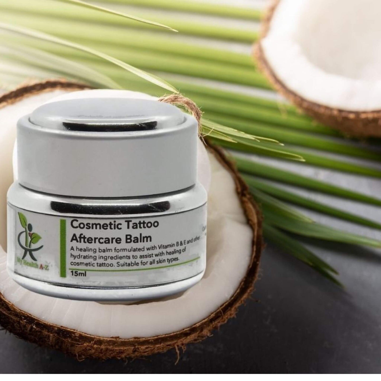 'My Health A-Z' Cosmetic Tattoo Aftercare Balm jar on a coconut with palm leaves in the background