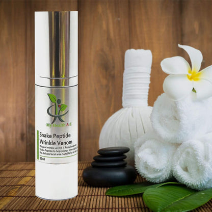 Skincare bottle 'My Health A-Z' Snake Peptide Wrinkle Venom on a wooden surface with flowers and massage stones.
